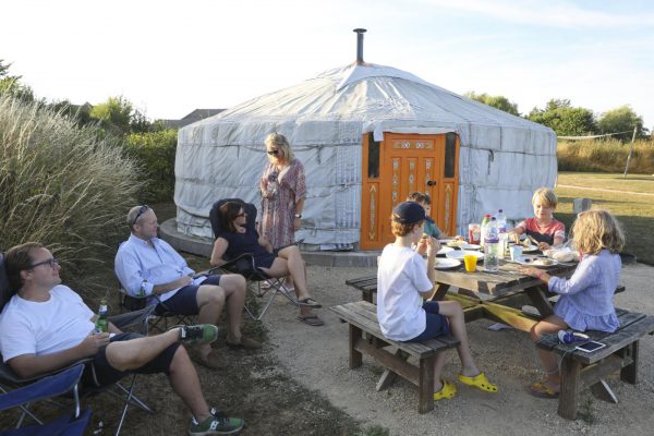 A Yurt with a family sitting outside